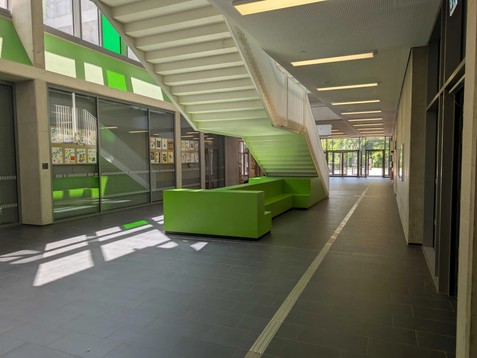 Foyer der Carl-von-Ossietzky-Gesamtschule mit hellgrüner Sitzlandschaft unter der Treppe